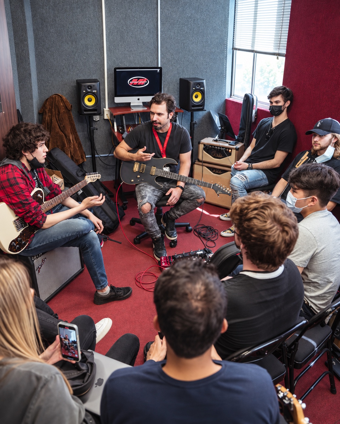 Andre Nieri ensinando guitarra em uma aula com alunos